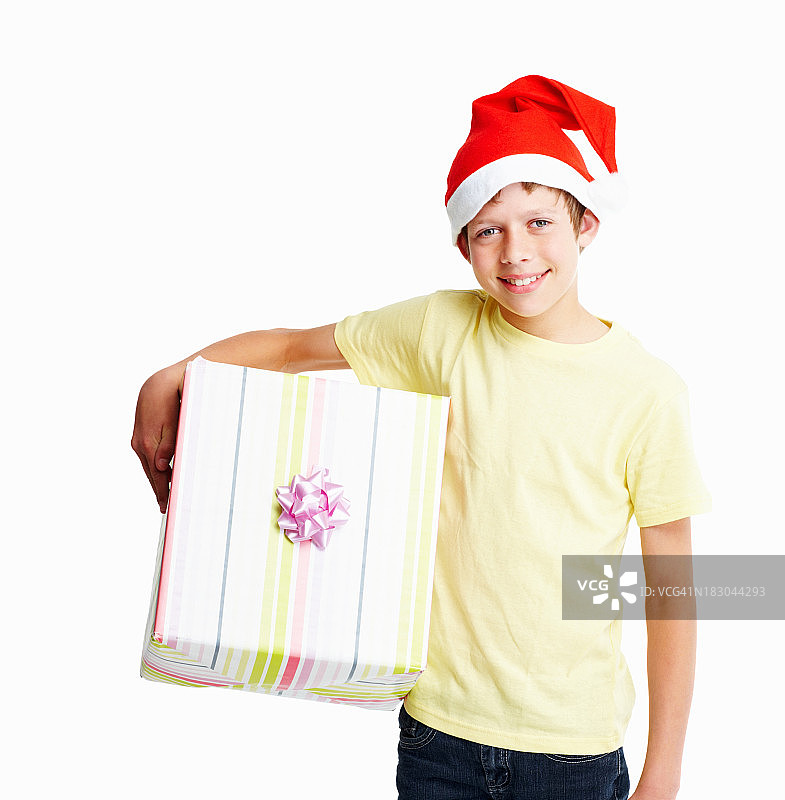 快乐的男孩戴着圣诞老人帽，拿着礼物图片素材