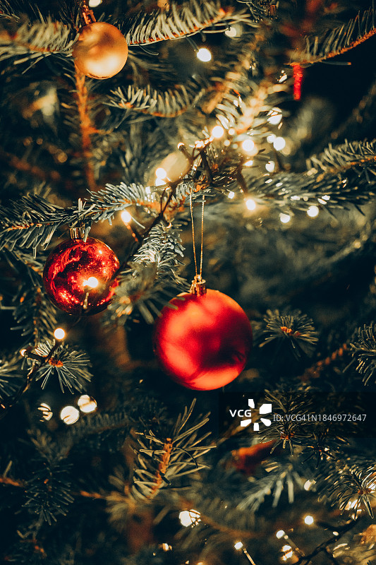 圣诞树上装饰着红色和金色的小玩意。新年庆祝理念。图片素材