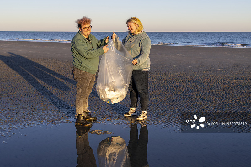 人们在清理海滩上的塑料垃圾图片素材