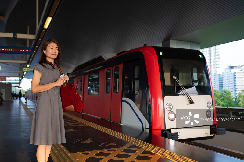 成熟的亚洲妇女在站台上等待捷运图片素材