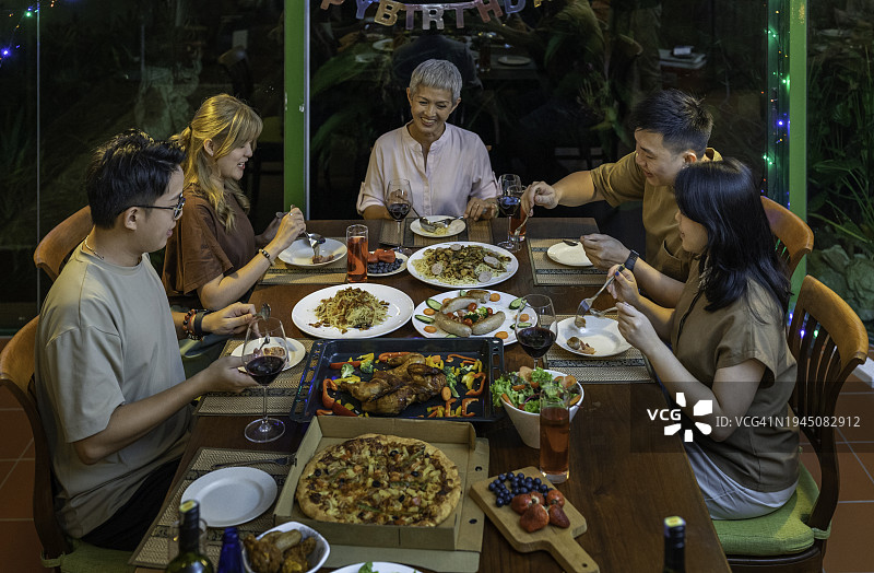一个亚洲的中国家庭和朋友在家里吃晚餐图片素材