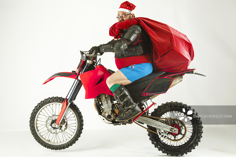 圣诞老人带着一袋礼物骑在摩托车上图片素材