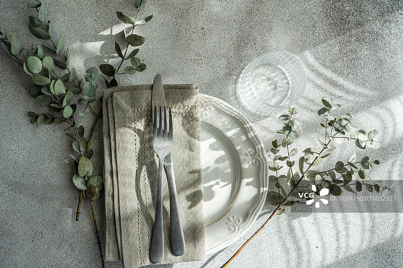 在阳光下，一个质朴的餐桌与桉树叶子的俯视图图片素材