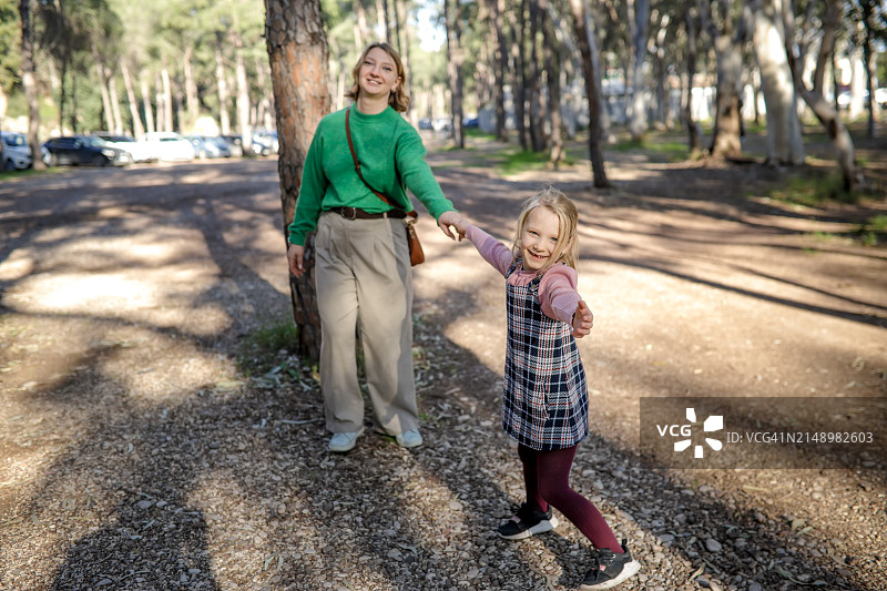 探索安塔利亚:妈妈和女儿手牵手走过桉树林图片素材