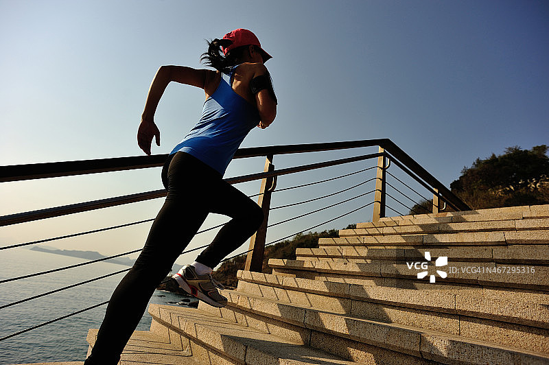 健康的生活方式亚洲妇女在楼梯海边跑步图片素材