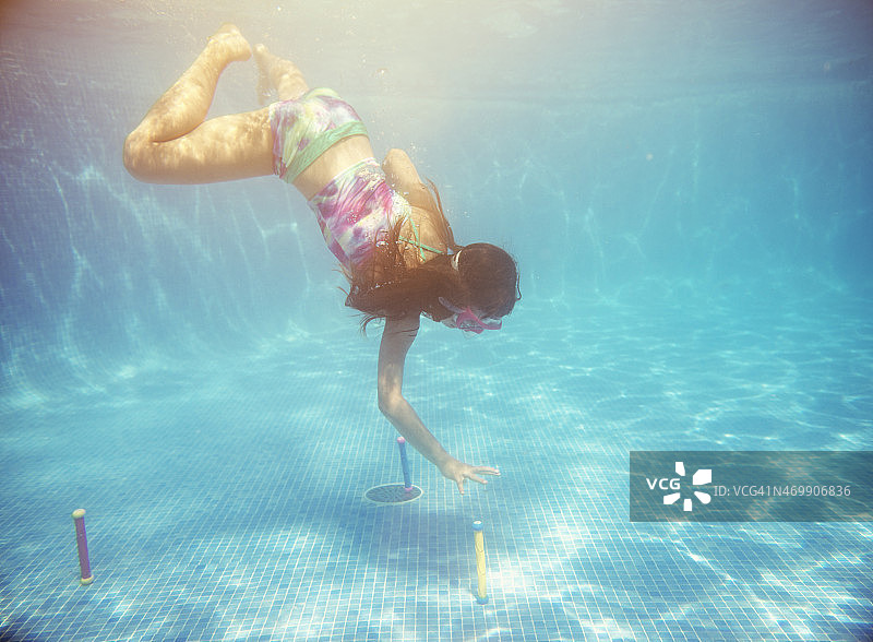 小女孩在水下游泳，伸手去拿潜水棒图片素材