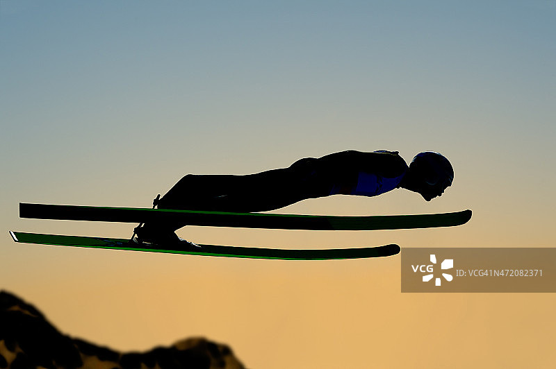 日落时跳台滑雪飞行的剪影图片素材