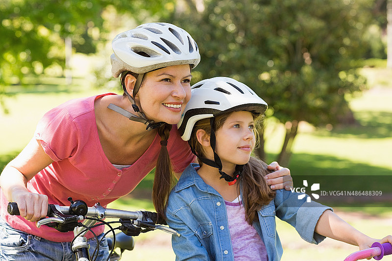 微笑的女人和她的女儿骑自行车图片素材