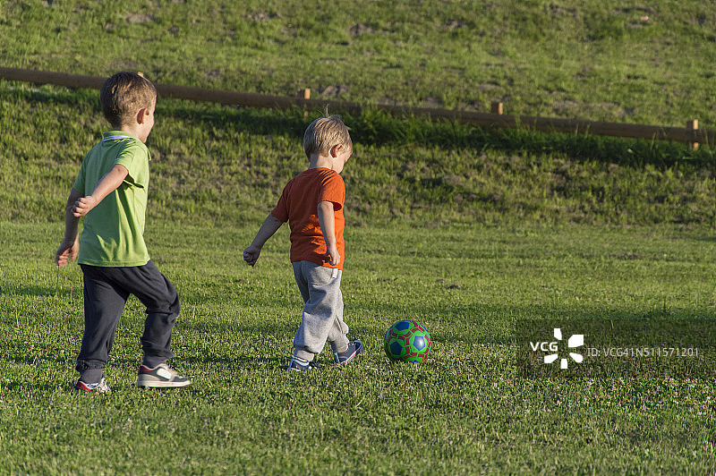 两个小男孩追着球跑图片素材