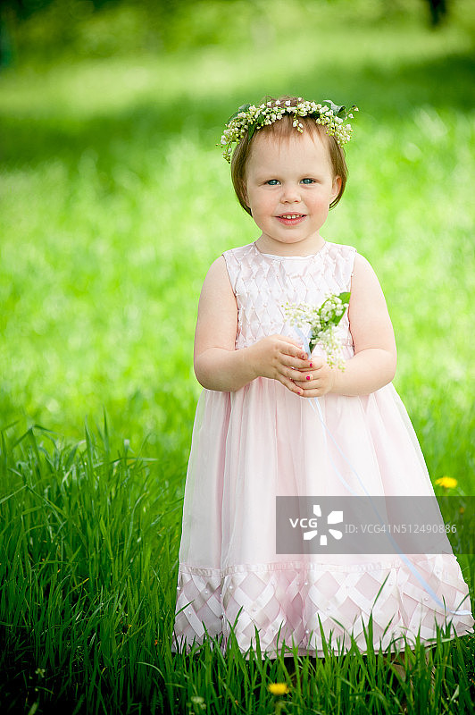 可爱的小女孩戴着花环在户外微笑图片素材