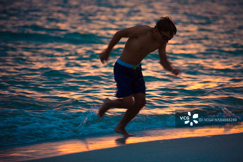 日落时在海滩上跑步图片素材