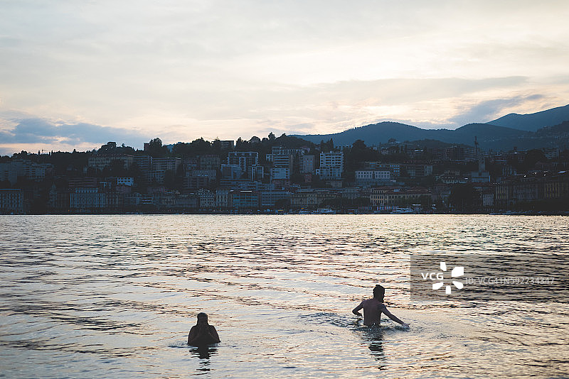 两名游客在瑞士卢加诺湖游泳的剪影图片素材