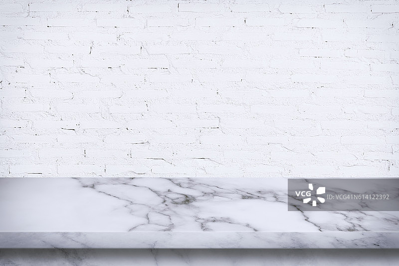 空大理石桌子与白色砖墙背景。图片素材