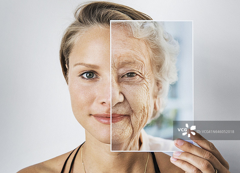 一个年轻的女人拿着一张老妇人的照片图片素材
