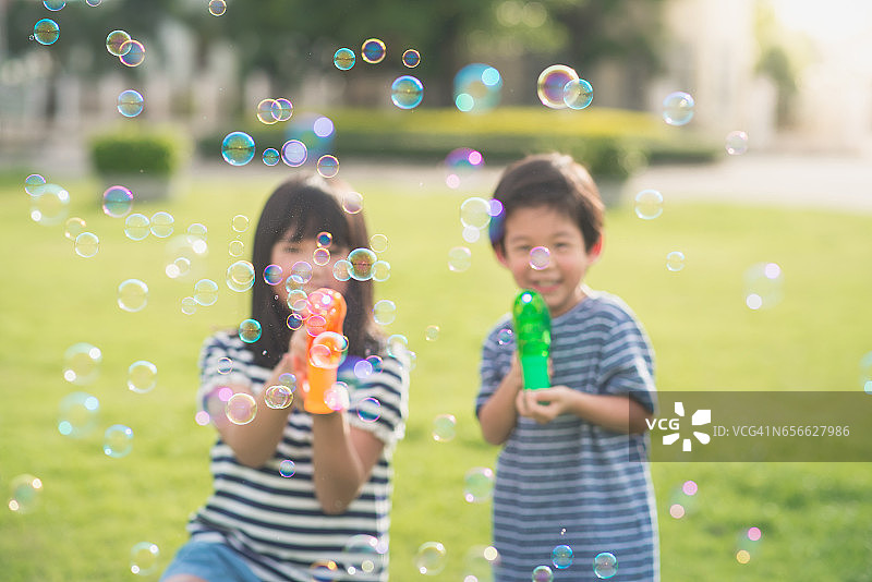 亚洲小孩用泡泡枪打泡泡图片素材