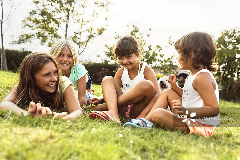 四个女孩一起在草地上玩图片素材