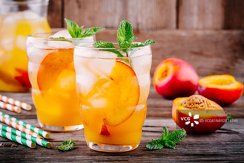 夏季冷饮:自制水蜜桃柠檬水加冰块和薄荷杯图片素材