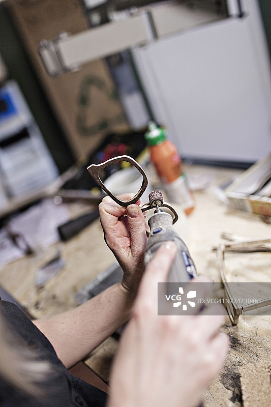 裁剪图像的女性业主制作眼镜与工作工具在车间图片素材