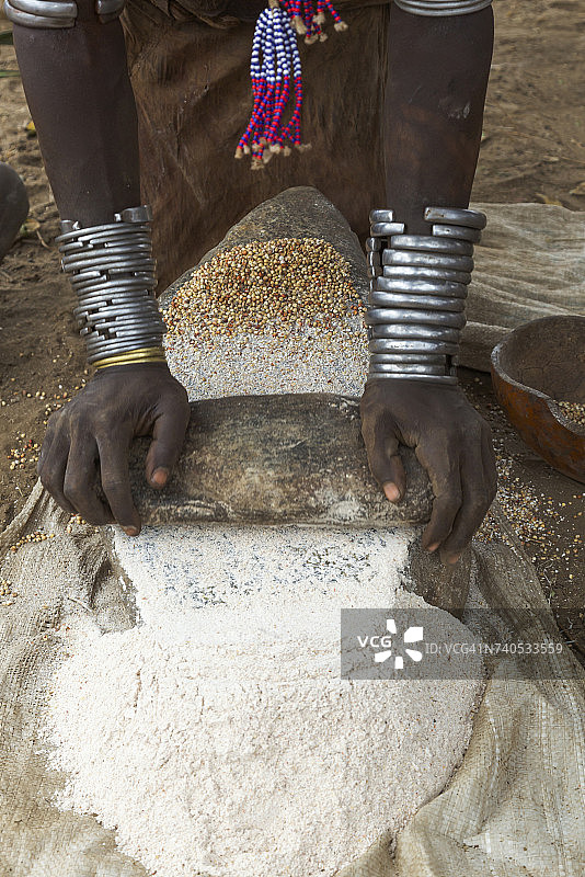 埃塞俄比亚南奥莫，妇女用石头把谷物磨成面粉图片素材
