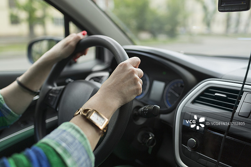 裁剪图像的女人戴着手表驾驶汽车图片素材