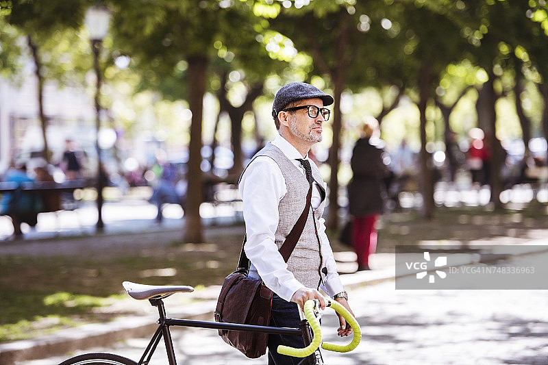 成熟的商人在城市里骑自行车图片素材