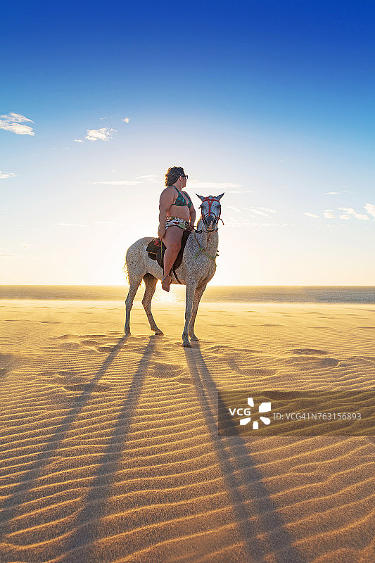 女人在沙滩上骑马，侧视图，杰里科阿拉，塞阿拉，巴西，南美洲图片素材