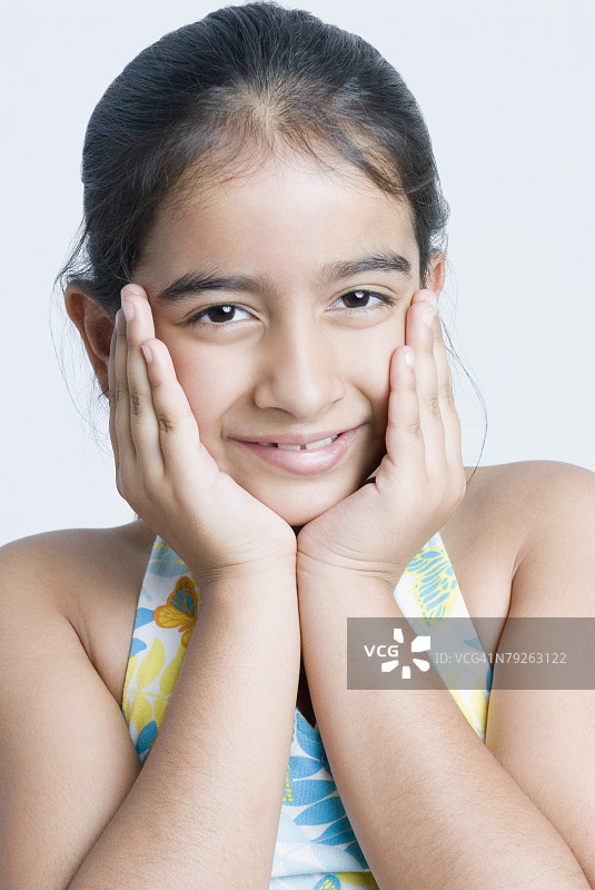 一个女孩双手抱头微笑的肖像图片素材