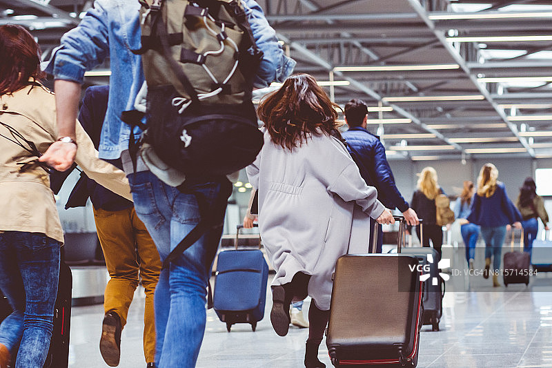 旅客携带行李在机场走廊图片素材