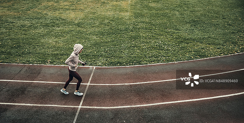 在体育场跑道上跑步的女人图片素材