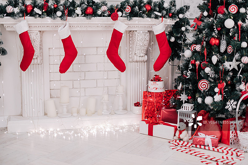 一个漂亮的装饰明亮的红色圣诞袜挂在壁炉等待礼物的特写。图片素材