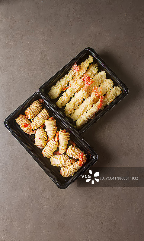 虾仁炸卷，配甜辣酱和筷子。黑暗的背景。图片素材