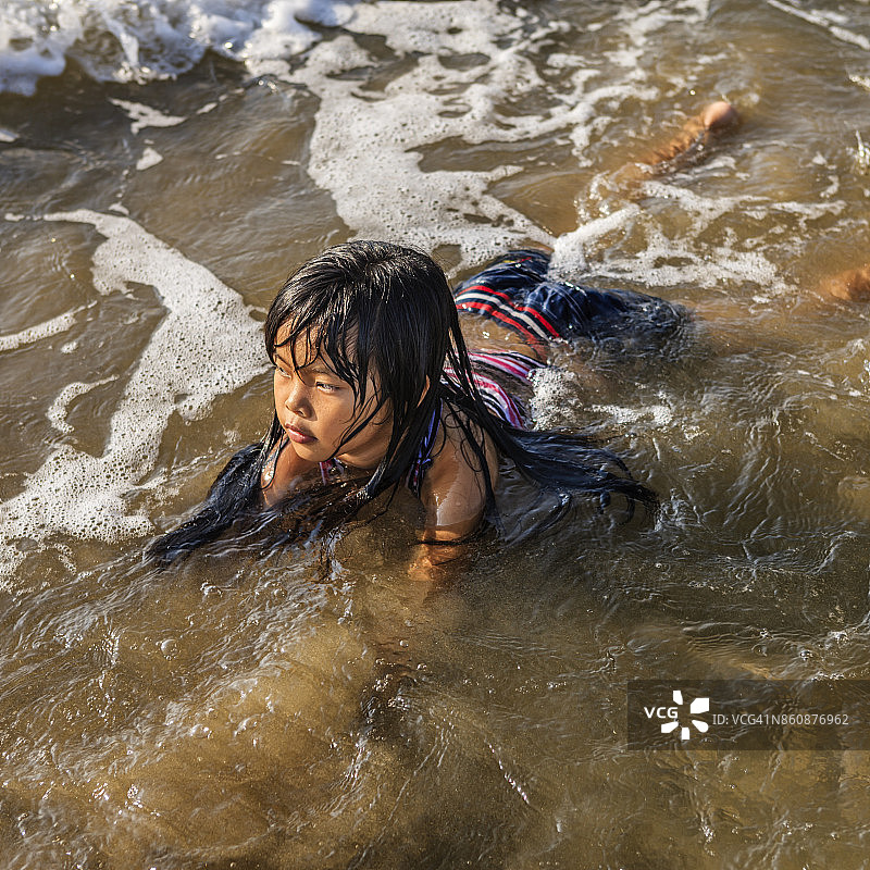 越南的一个小女孩在海滩上玩耍图片素材