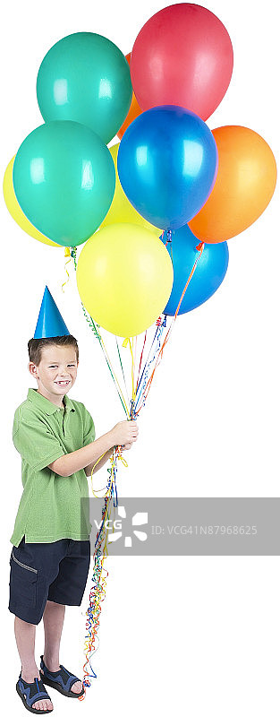 微笑的小男孩在派对帽子拿着一堆气球图片素材