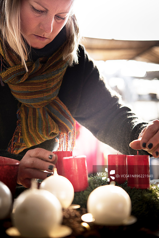 女人用蜡烛做圣诞花环图片素材
