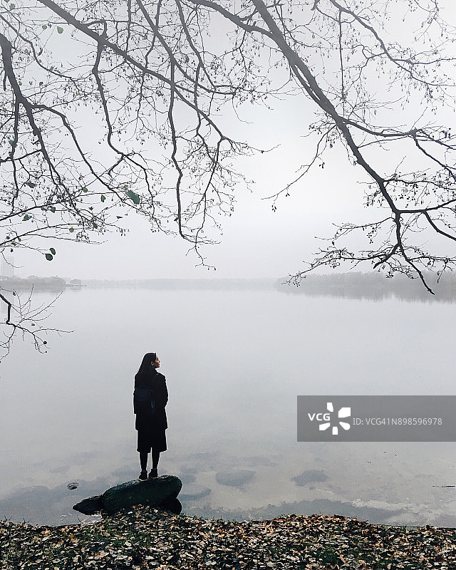 一个女人的剪影站在河岸上，明斯克，白俄罗斯图片素材