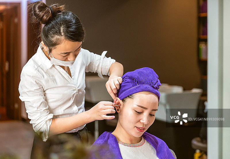 一个女人正在美发店做发型图片素材