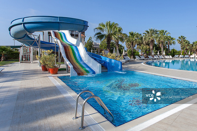游泳池与水滑梯在一个豪华的热带酒店度假图片素材