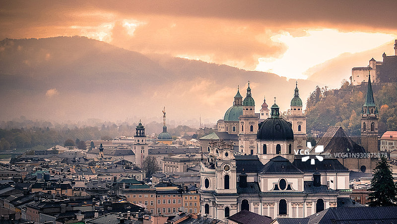 日落戏剧性的天空照耀在城市萨尔茨堡，奥地利图片素材