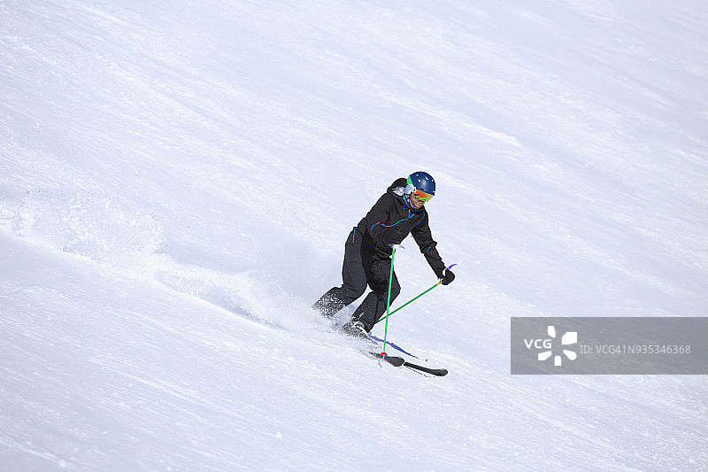 在欧洲意大利阳光明媚的滑雪胜地Dolomites滑雪的男子。业余的冬季运动。图片素材