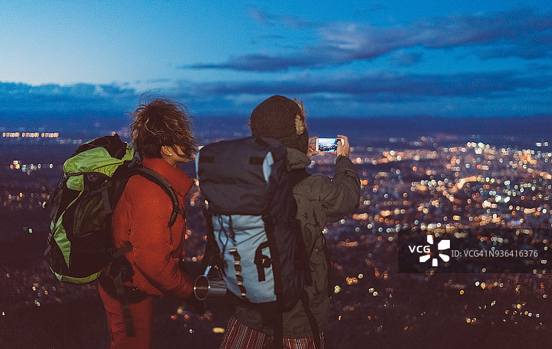 傍晚时分，一对夫妇在山顶上拍照图片素材