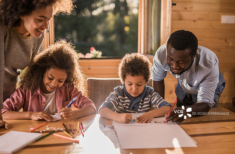 快乐的非裔美国人家庭在家里一起涂色，玩得很开心。图片素材