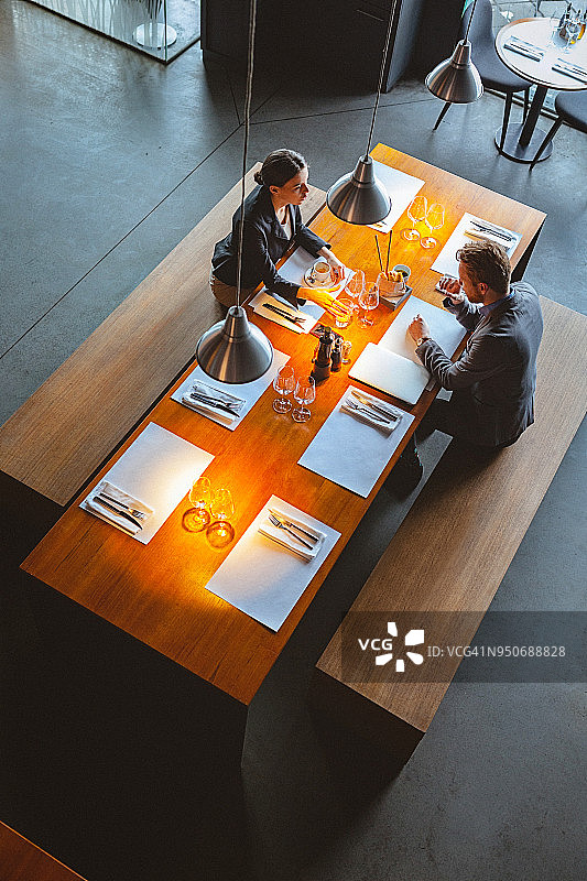 一个男人和女人在一个高端餐厅的午餐时间交谈的高角度视图图片素材