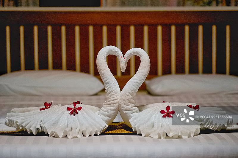 现代卧室的室内设置在白色的毯子和木床上为蜜月床。图片素材