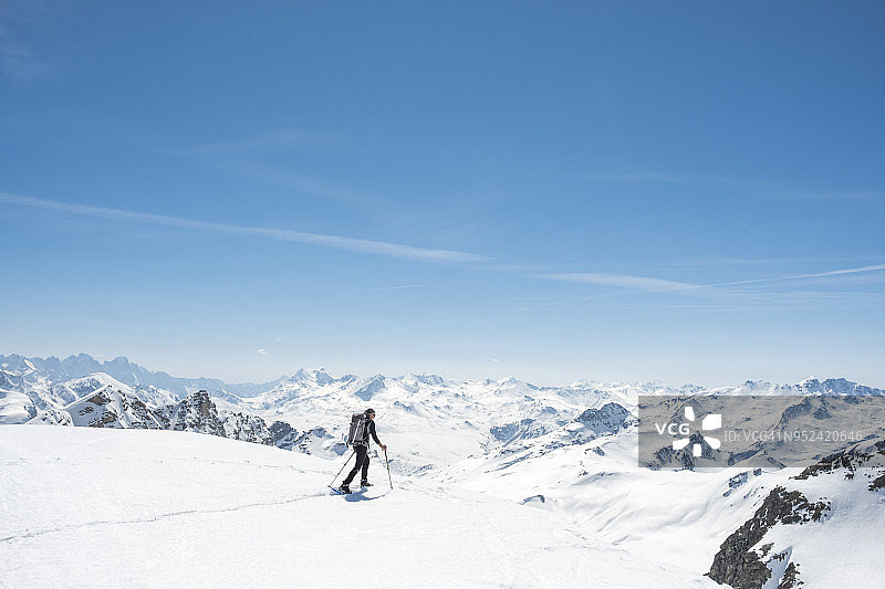 一个登山者站在白雪覆盖的雄伟山谷里图片素材