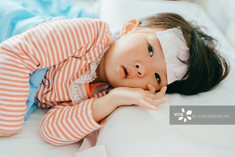 亚洲生病的小女孩躺在床上发高烧图片素材
