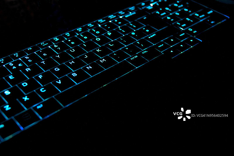 在黑暗的房间里点亮电脑键盘图片素材