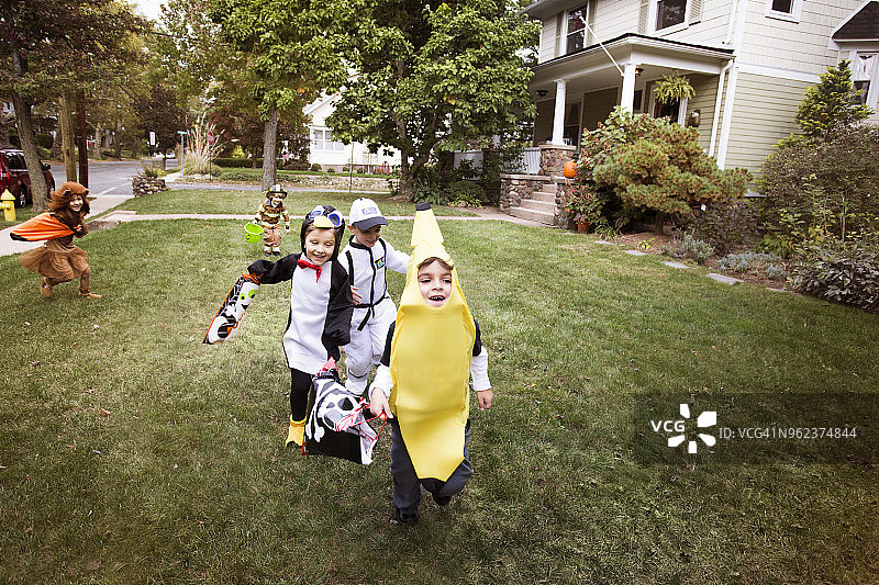 万圣节期间，孩子们穿着万圣节服装在院子里跑来跑去图片素材