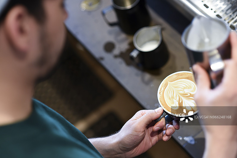 高角度的咖啡师在咖啡店制作泡沫饮料图片素材