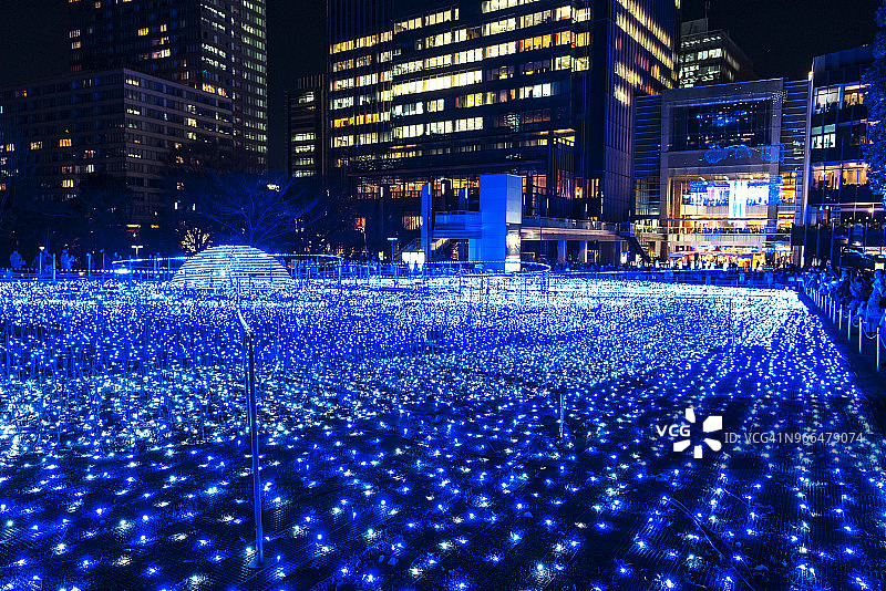 2017年12月21日，超过50万盏LED灯在东京六本木的星光花园(草地广场)展示，在夜晚发光。人们在观察和拍摄照明。图片素材