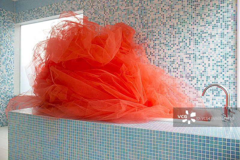 设计师浴缸充满明亮的橙色织物图片素材